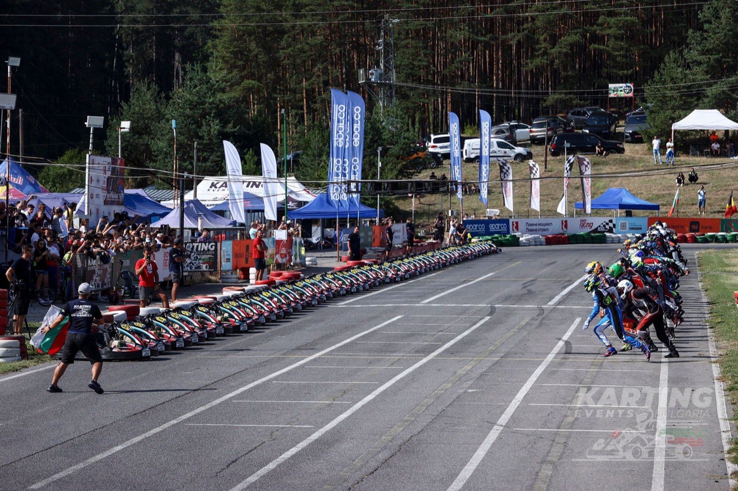 A grid of karts lined up on the start straight at Kyustendil